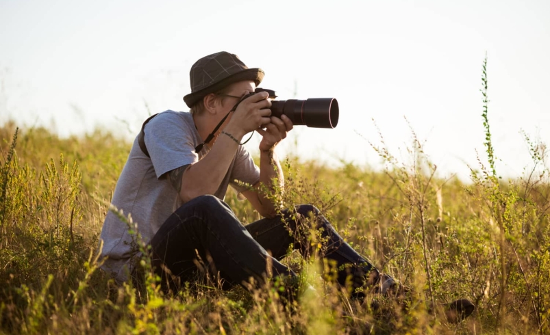 مرد جوان در حال فیلمبرداری B-Roll در طبیعت